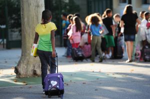 A pupil arrives in the courtyard of the Abbe de l'Epee elementary school on September 3, 2013 in Marseille, southern France, prior to enter her classroom on the first day of school. More than 12 million pupils went back to school today in France