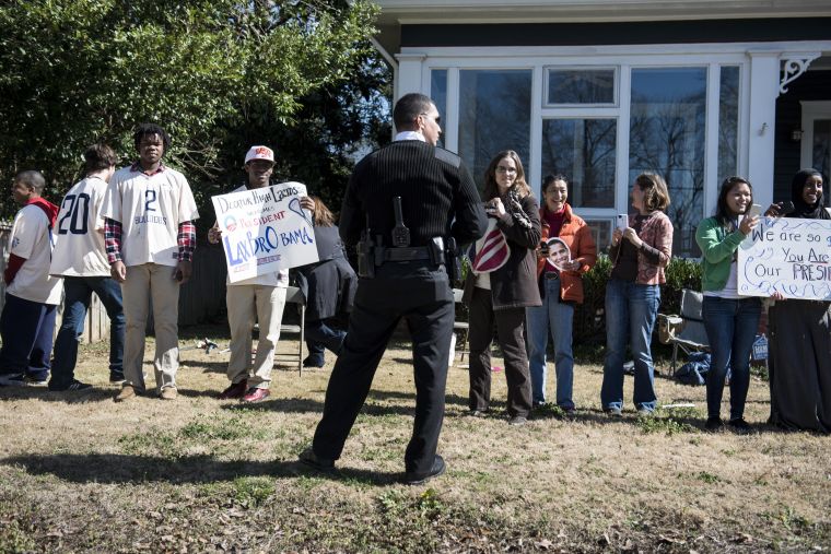 People watch as a President Obama's motorcade travels to the Decatur Community Recreation Center in Decatur.