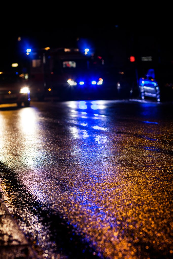 Ambulance, reflections on wet asphalt