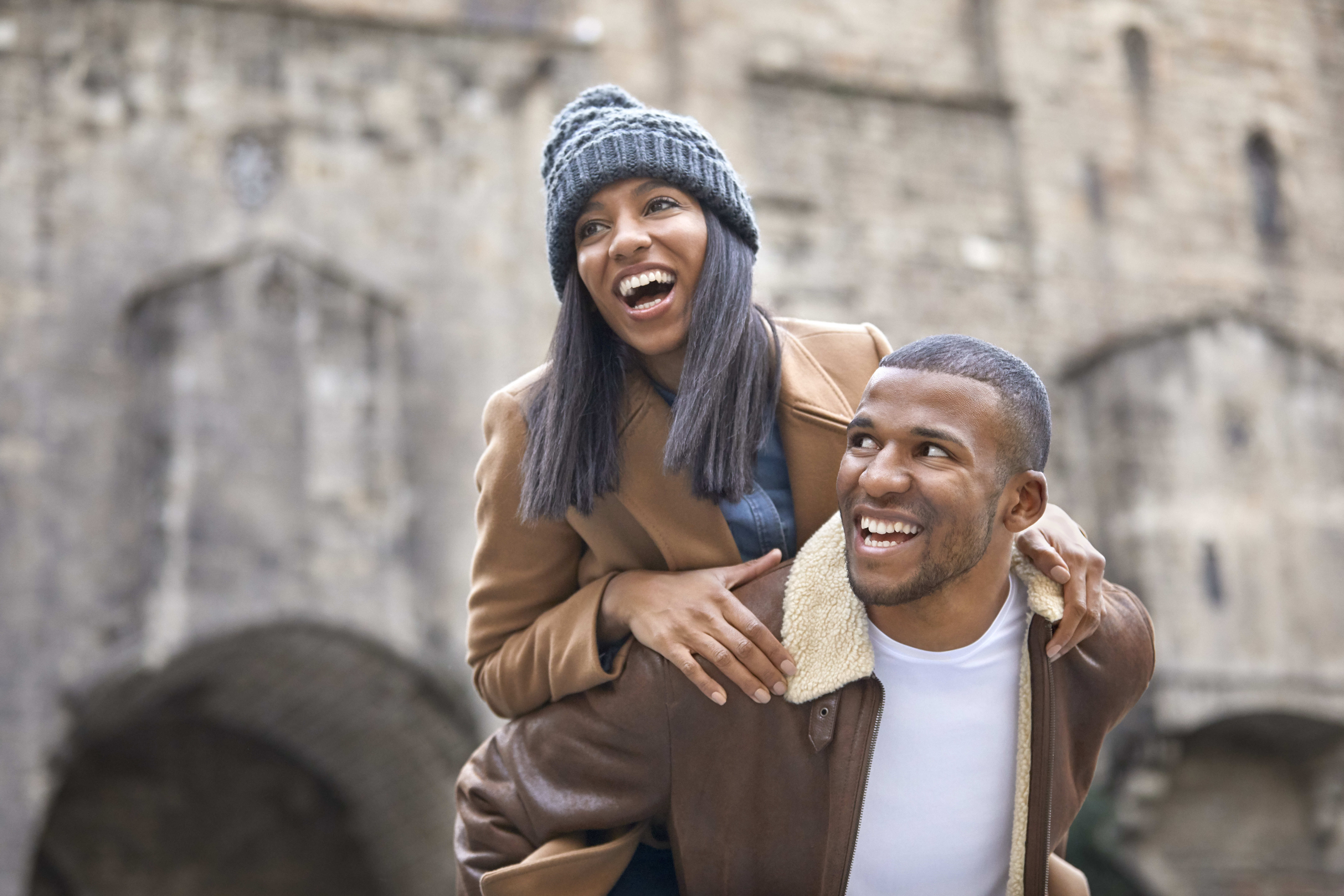 Couple enjoying piggyback ride in city