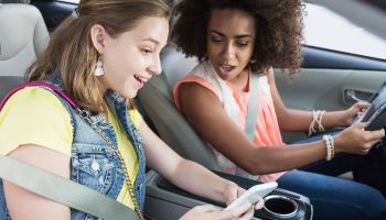 Teenage girls in car distracted by mobile phone