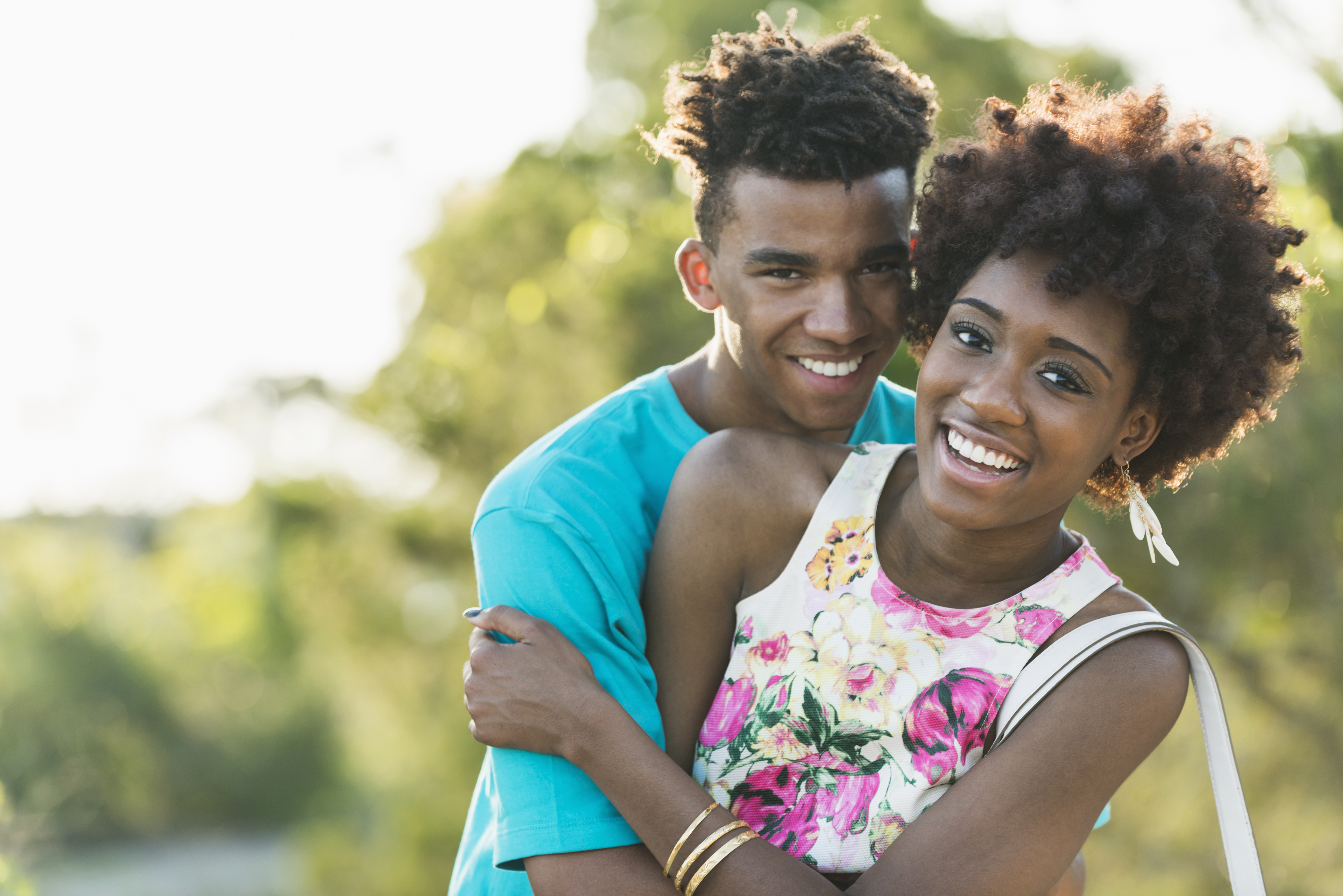 Happy young black couple on sunny summer day in park