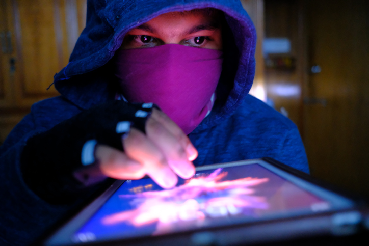young hacker with digital tablet stealing information- data security theft idea