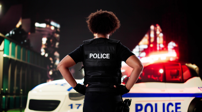 Young African American police officer on night patrol